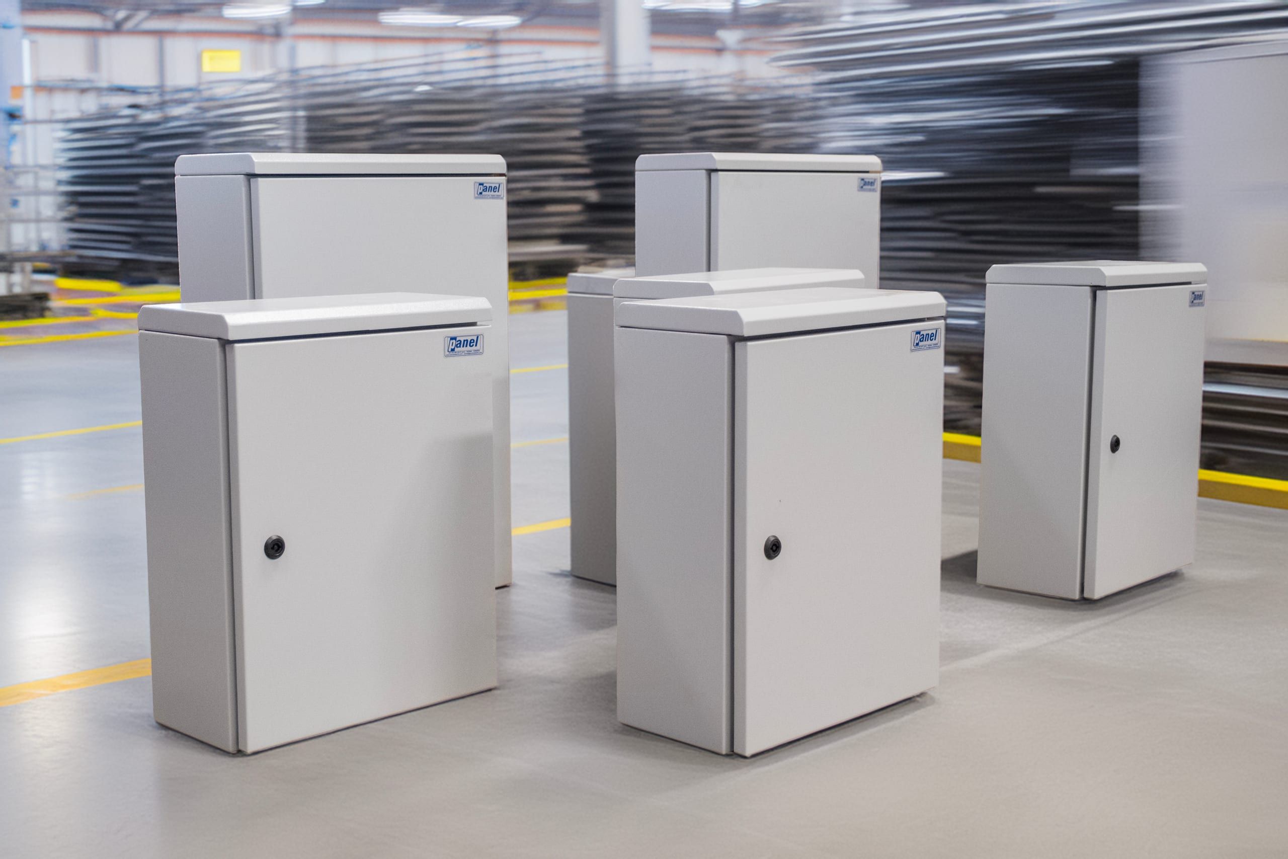 Wall-mounted low voltage panels with the Panel logo on the factory floor