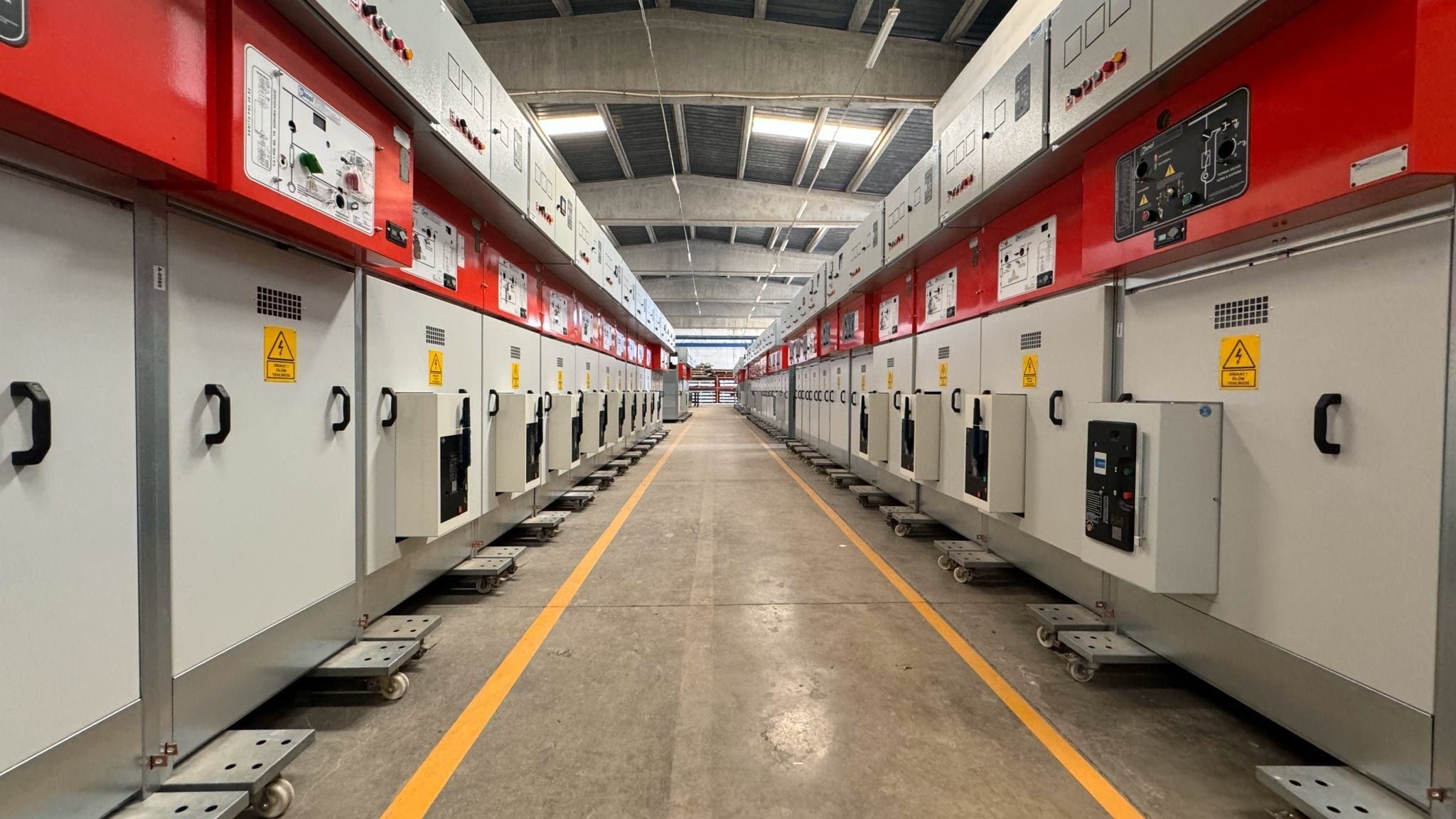 Row of 36 kV metal-enclosed modular switchgear cubicles ready for shipment in the factory hall
